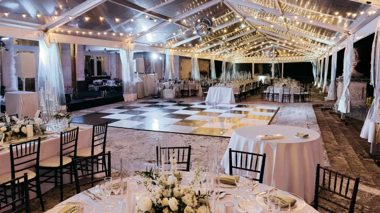 Luxury checkered dance floor rental under clear tent with lighting in Miami
